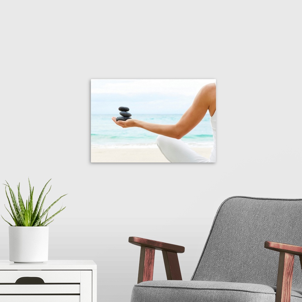 A modern room featuring Photograph taken from behind a woman as she sits on the beach with her legs crossed and stretches...