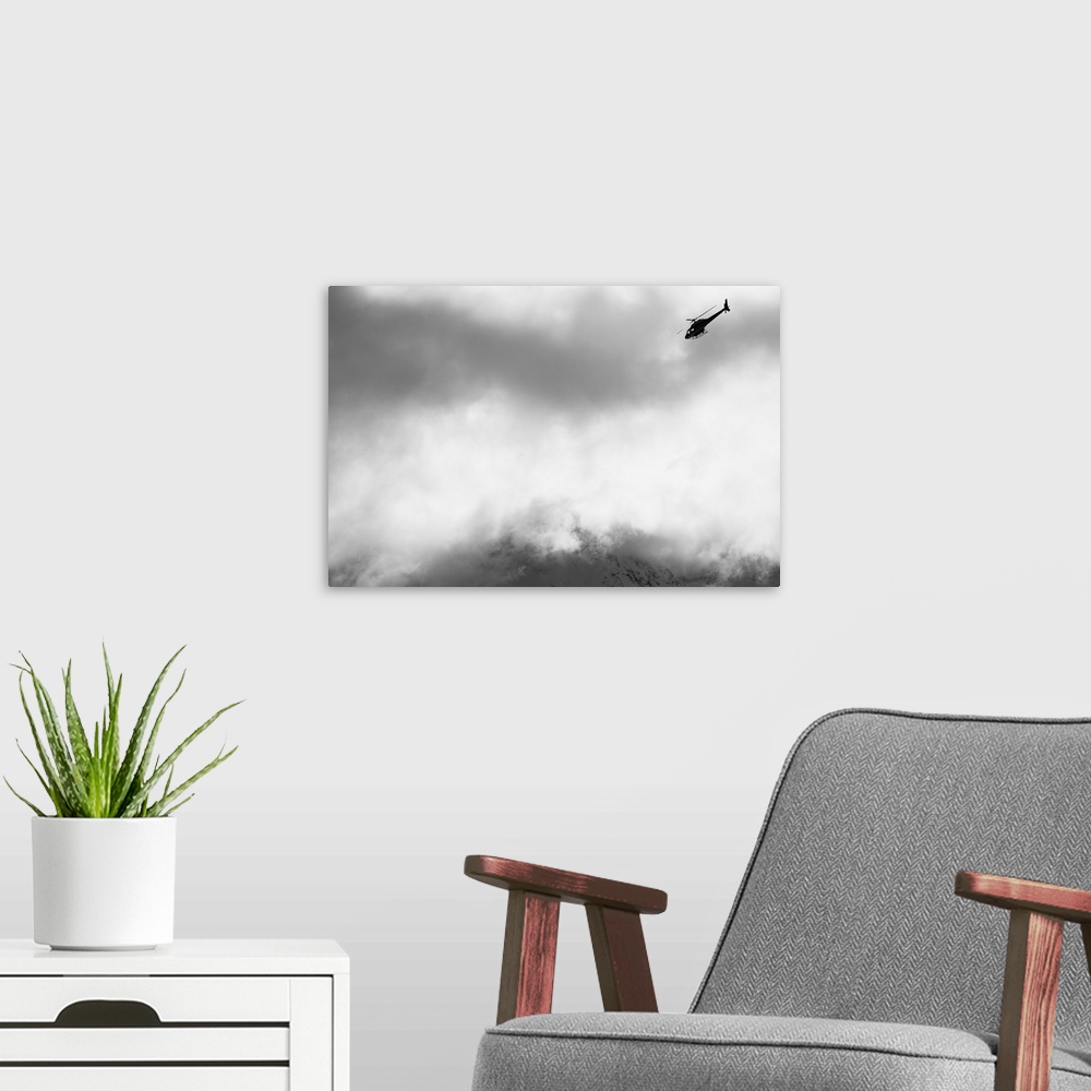 A modern room featuring Heli ski helicopter flying amongst fog and clouds, New Zealand