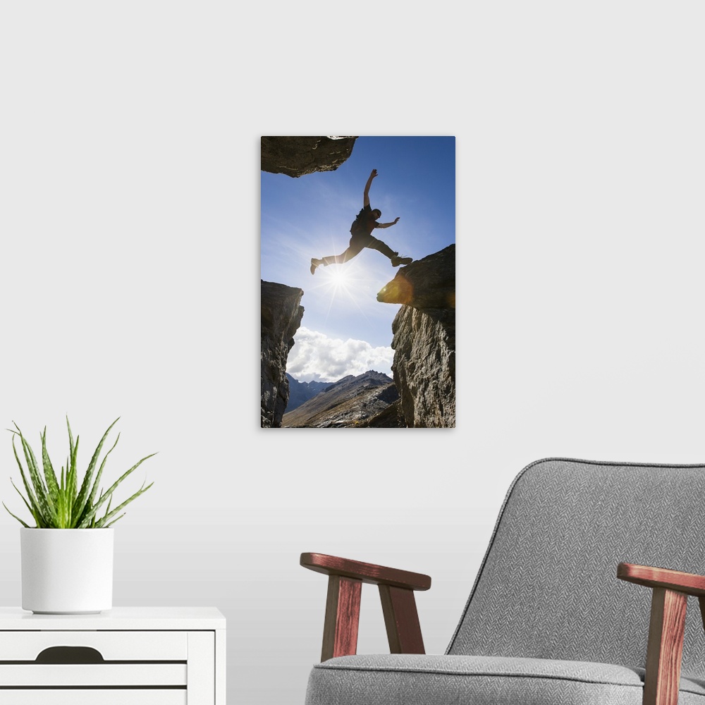A modern room featuring Backlit View Of Hiker Leaping Between Rocks Near Noatak River In The Brooks Range, Gates Of The A...