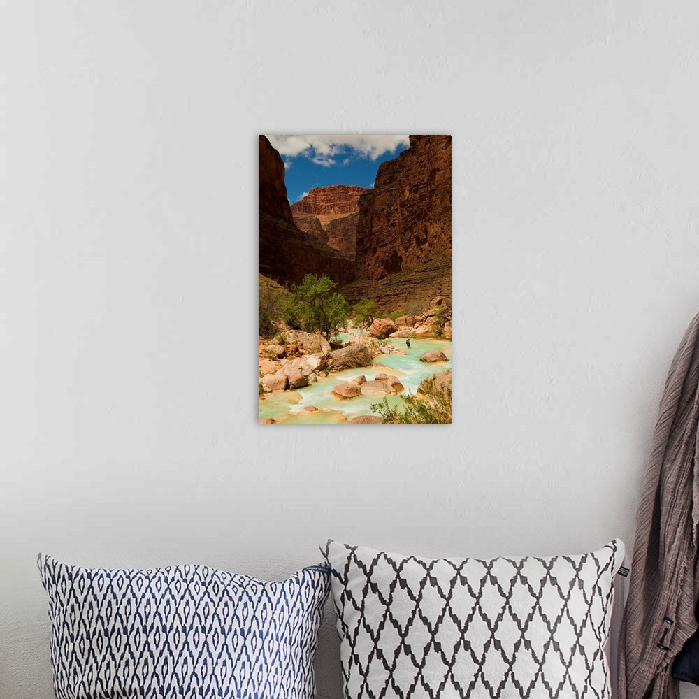 A bohemian room featuring Hiker walking in the turquoise waters of Havasu Canyon.
