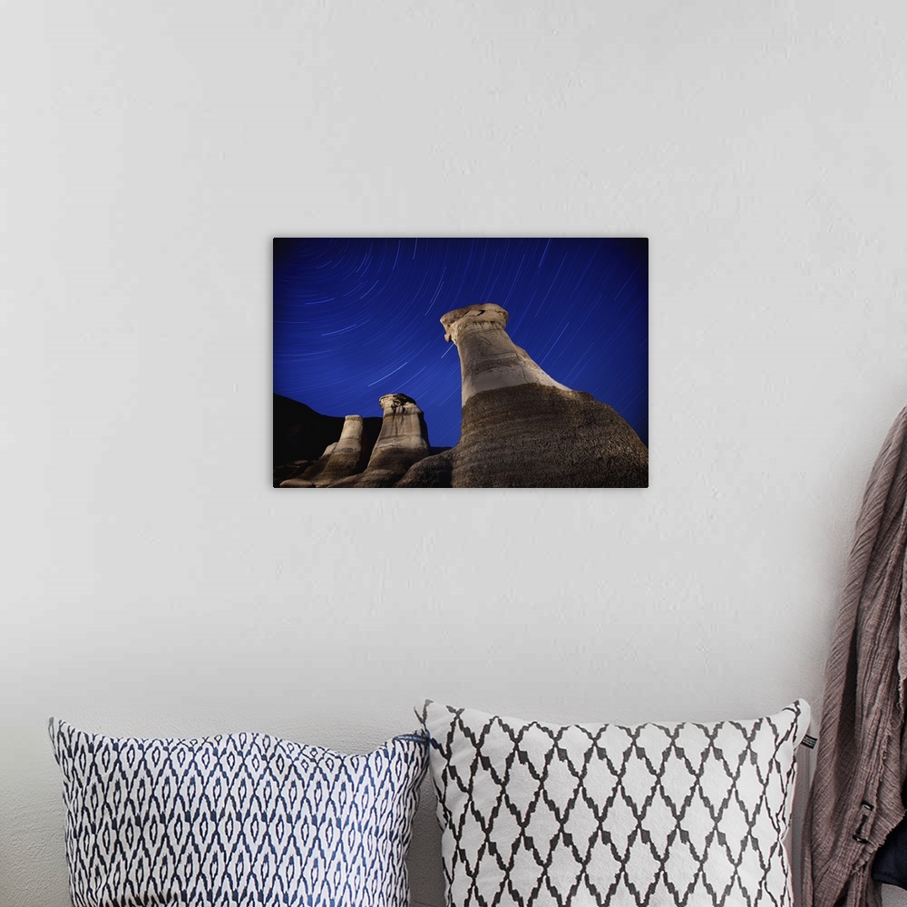 A bohemian room featuring Hoodoos And Star Trails In The Sky; Drumheller, Alberta, Canada
