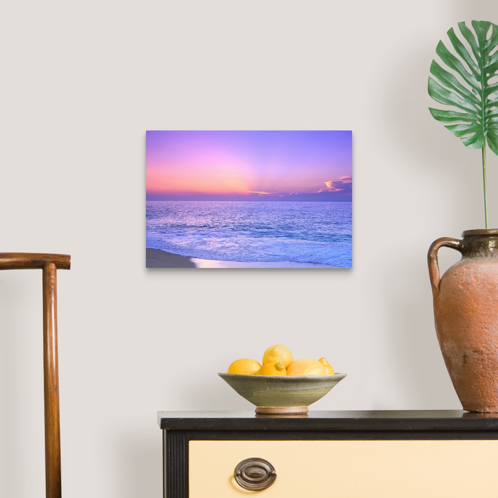 A traditional room featuring A breathtaking photograph of a sunset over the vast ocean giving the overall picture a soft color...