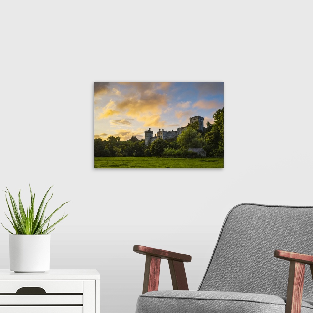 A modern room featuring Lismore Castle at sunrise with an epic dramatic sky; Lismore, County Waterford, Ireland.