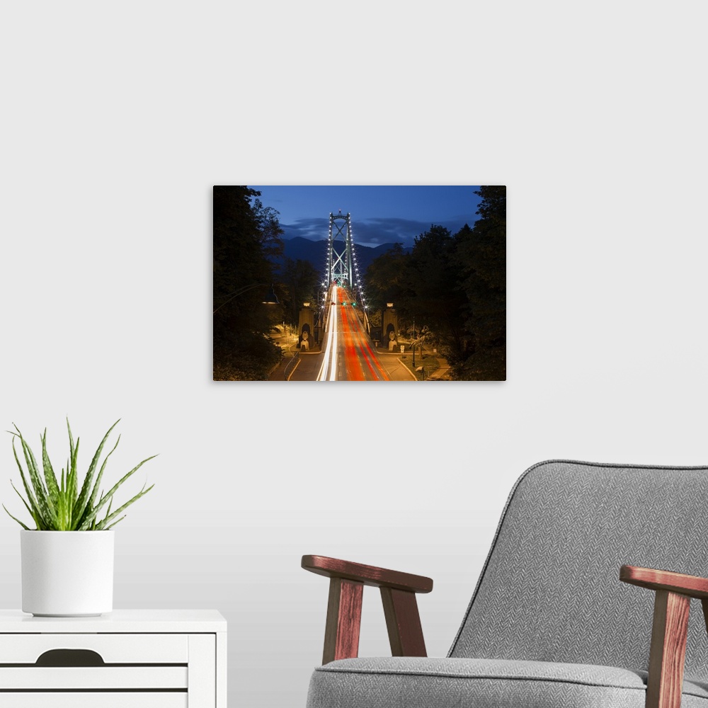 A modern room featuring Long Exposure Twilight Image Of The Lions Gate Bridge With Car Headlights Streaking Over The Brid...