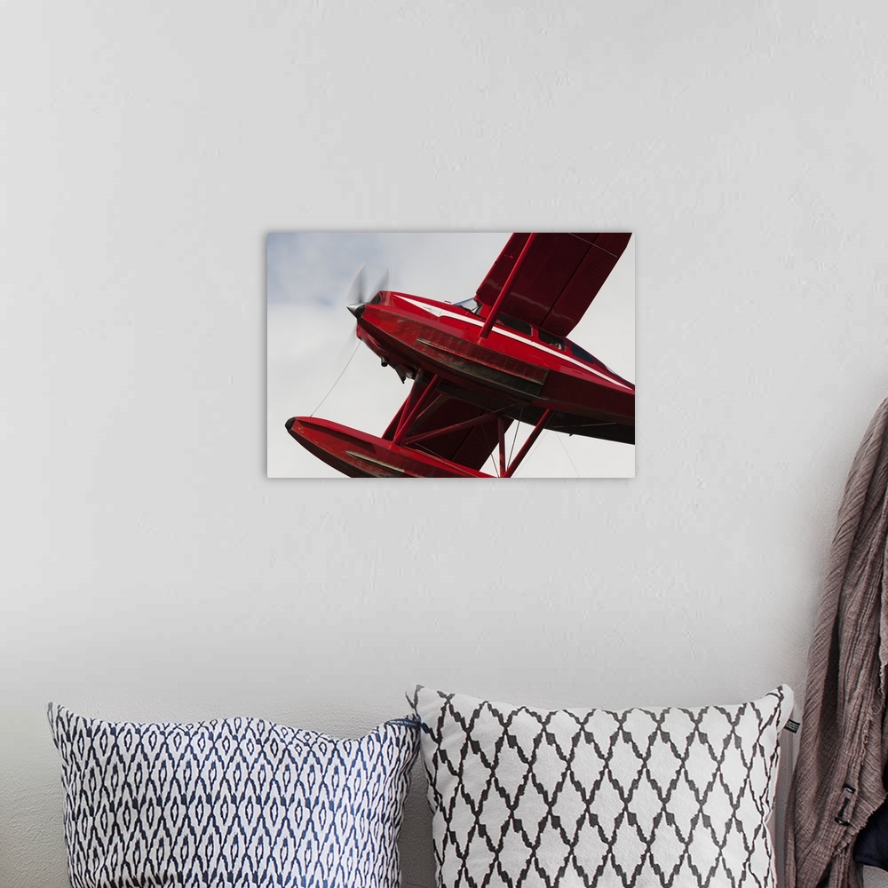 A bohemian room featuring Low Angle View Of A Red Float Plane Against A Cloudy Sky; Alaska, United States Of America