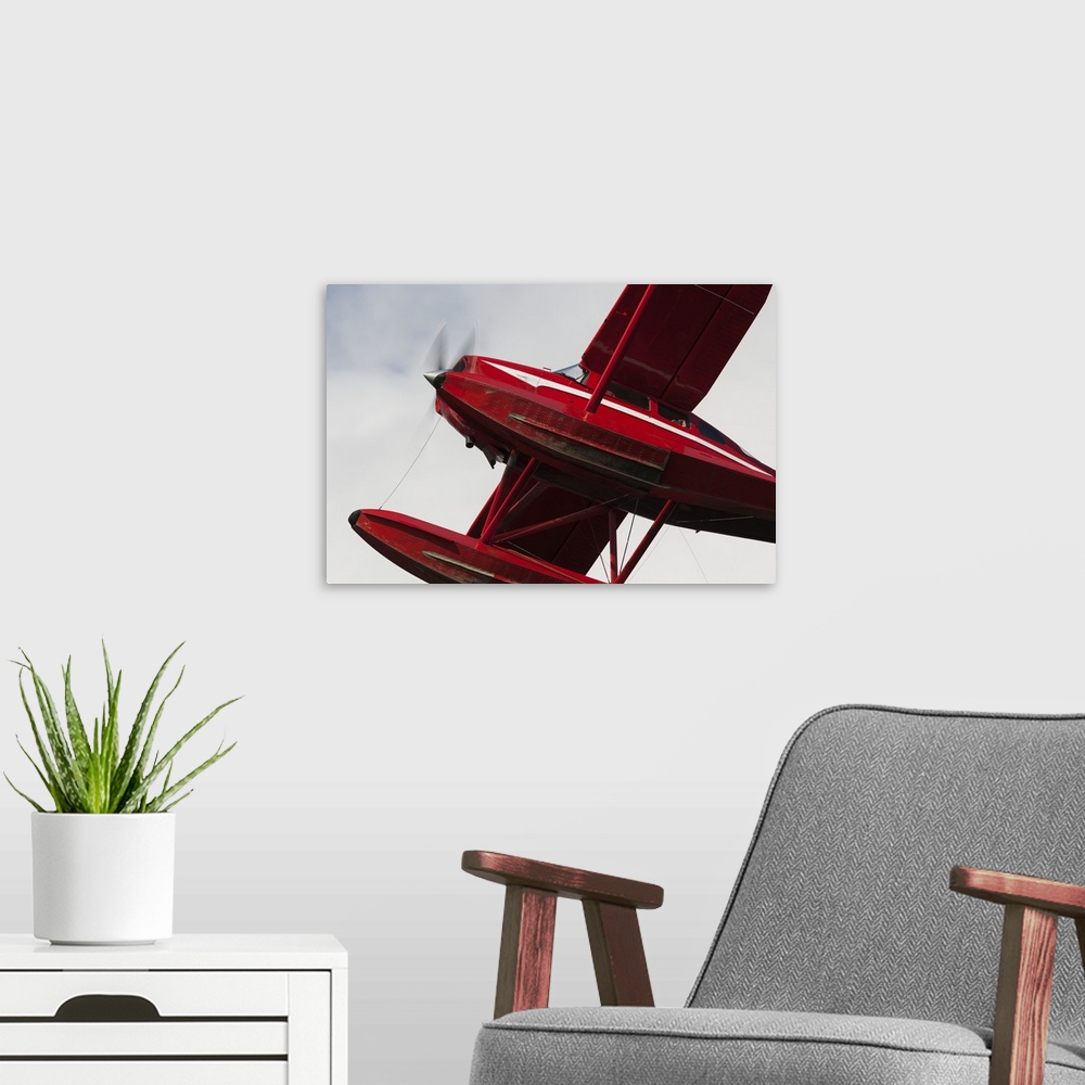 A modern room featuring Low Angle View Of A Red Float Plane Against A Cloudy Sky; Alaska, United States Of America
