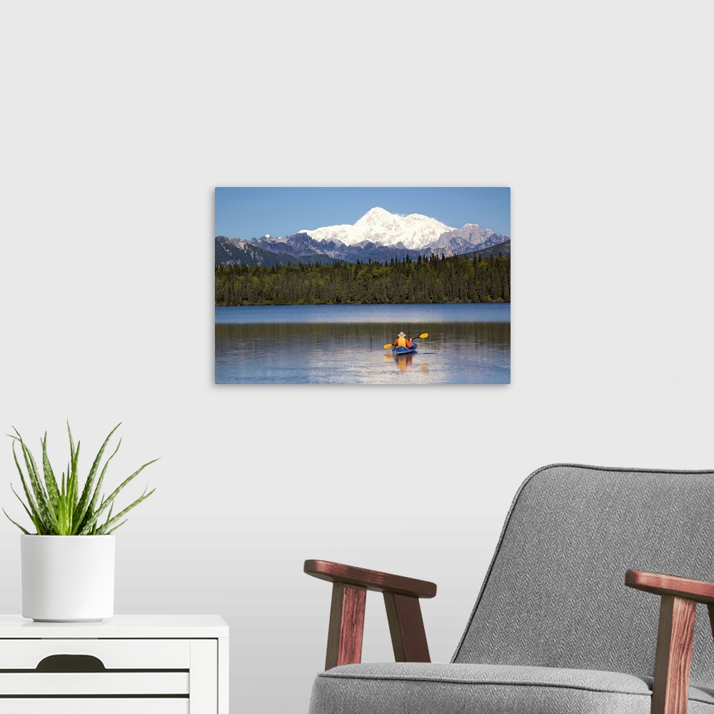 A modern room featuring A man paddles a Klepper kayak on Byers Lake, Denali State Park, Alaska. Mt. McKinley is in the ba...