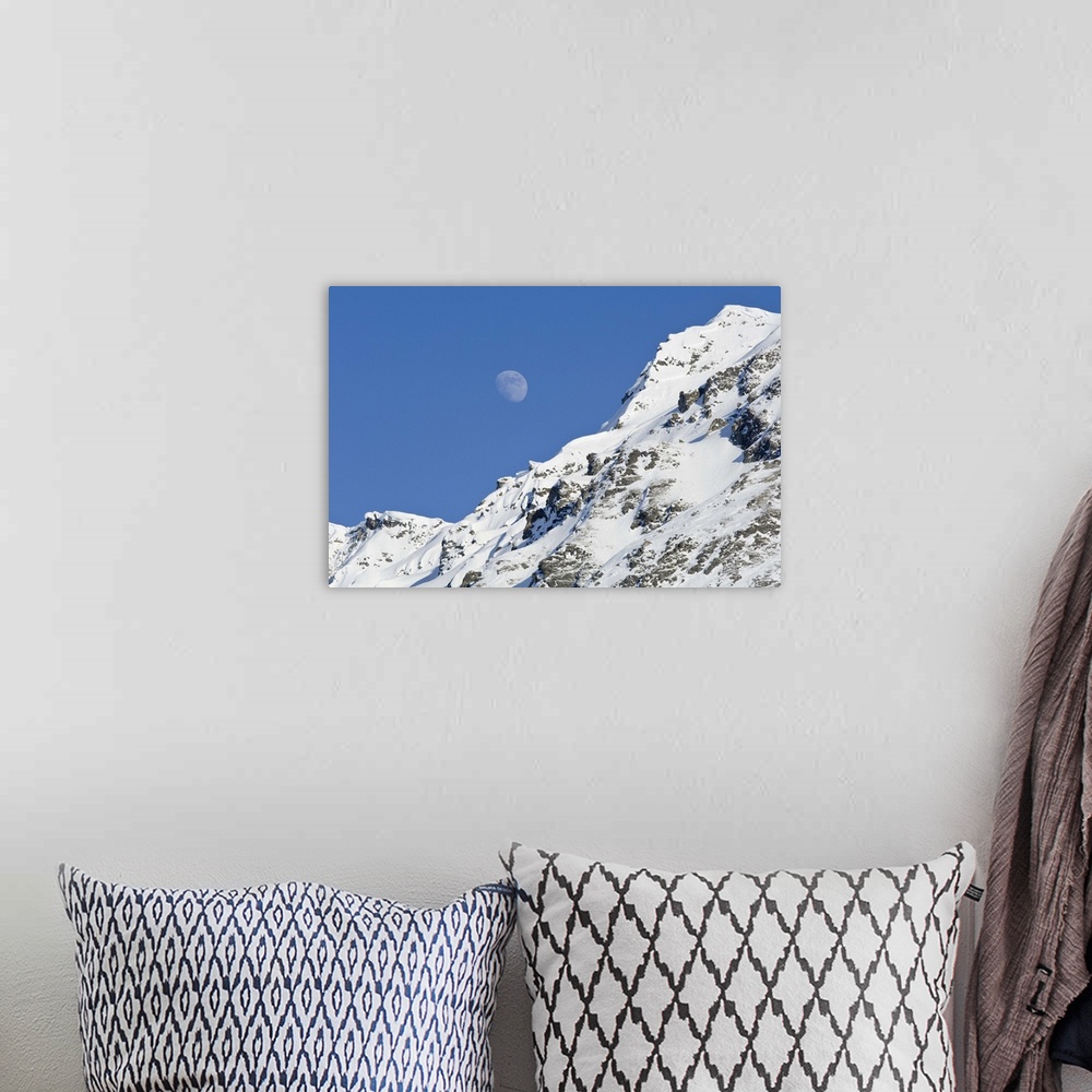 A bohemian room featuring Moon rising over snow covered mountain peak at Hatcher Pass in Southcentral Alaska.