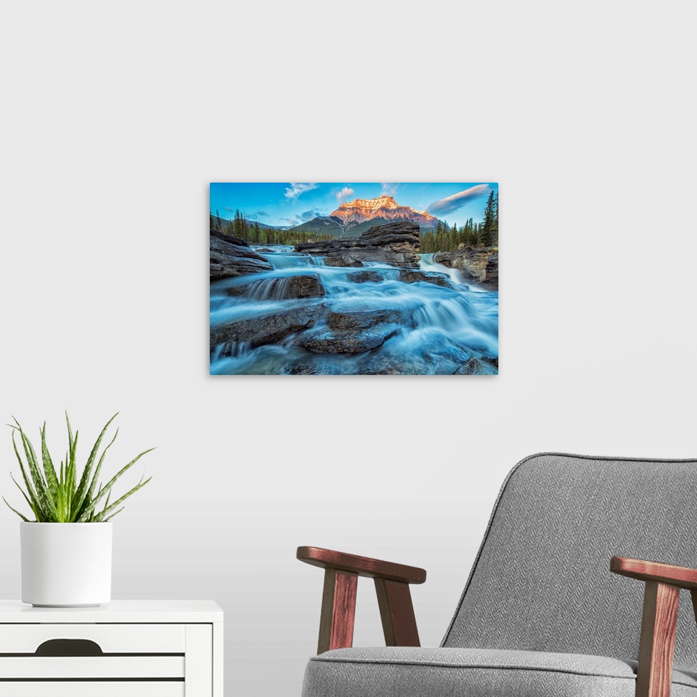 A modern room featuring Sunset lights up Mount Fryatt as the Athabasca River flows over Athabasca Falls in Jasper Nationa...