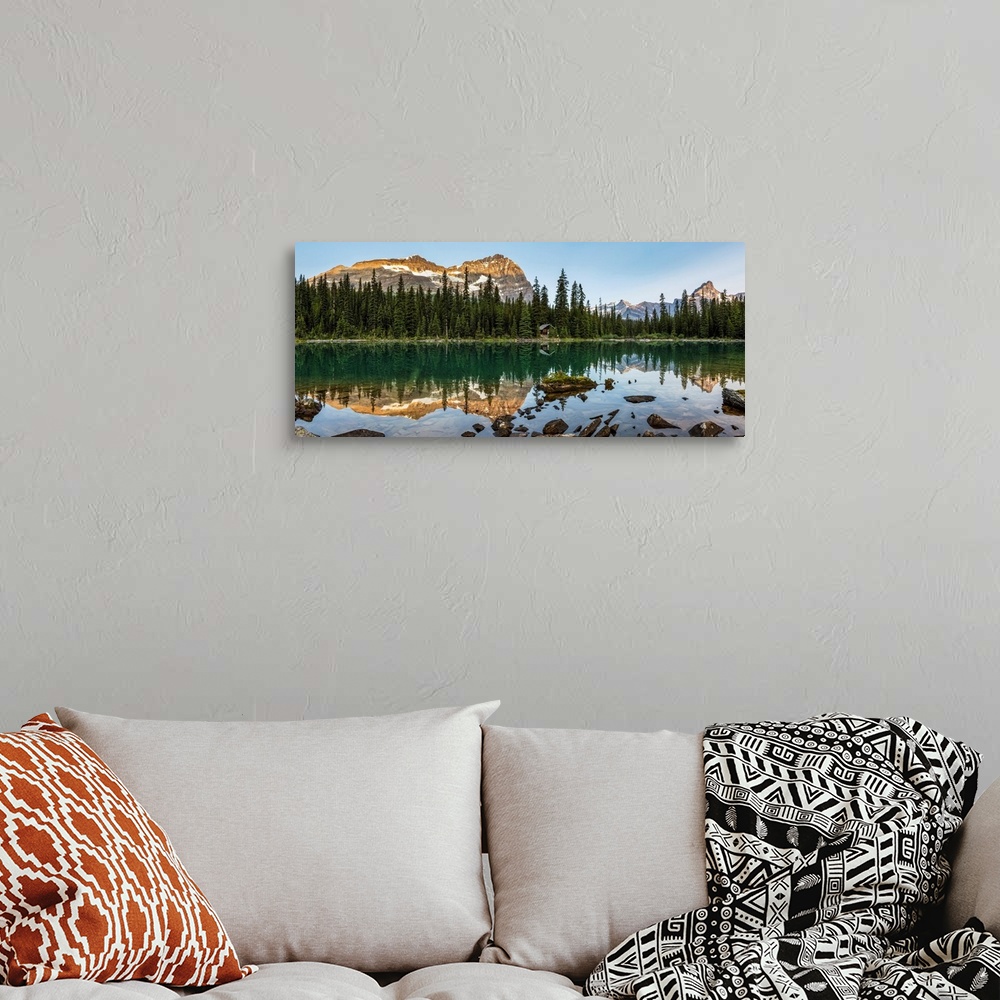 A bohemian room featuring Panorama of mountain range reflecting in an alpine lake with the glow of warm early morning light...