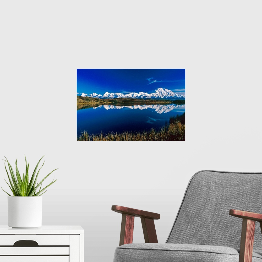 A modern room featuring Photograph of snow covered mountain range with waterfront.  The sky is clear and the mountains ar...