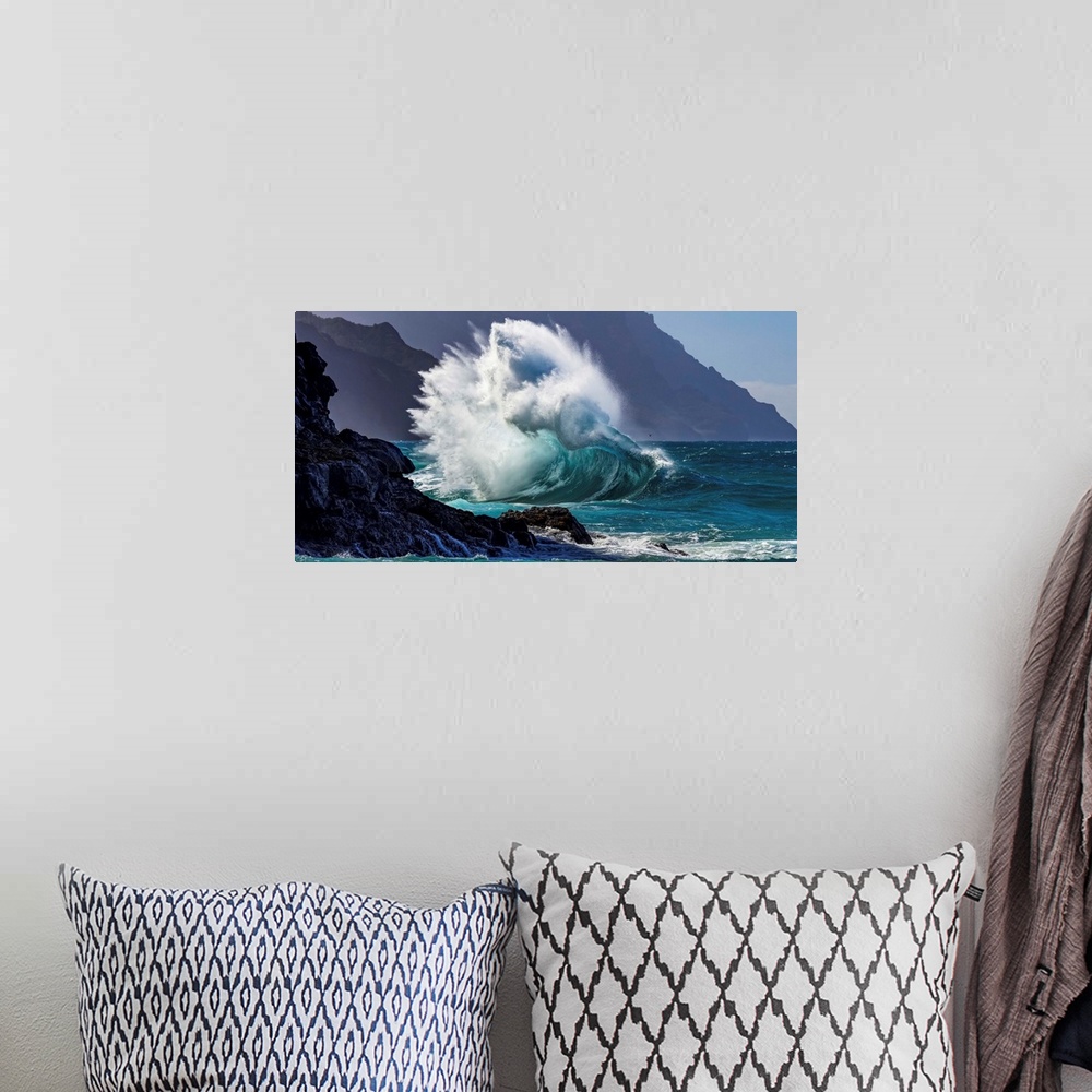 A bohemian room featuring Large ocean wave crashes into rock along the Na Pali Coast; Kauai, Hawaii, United States of America
