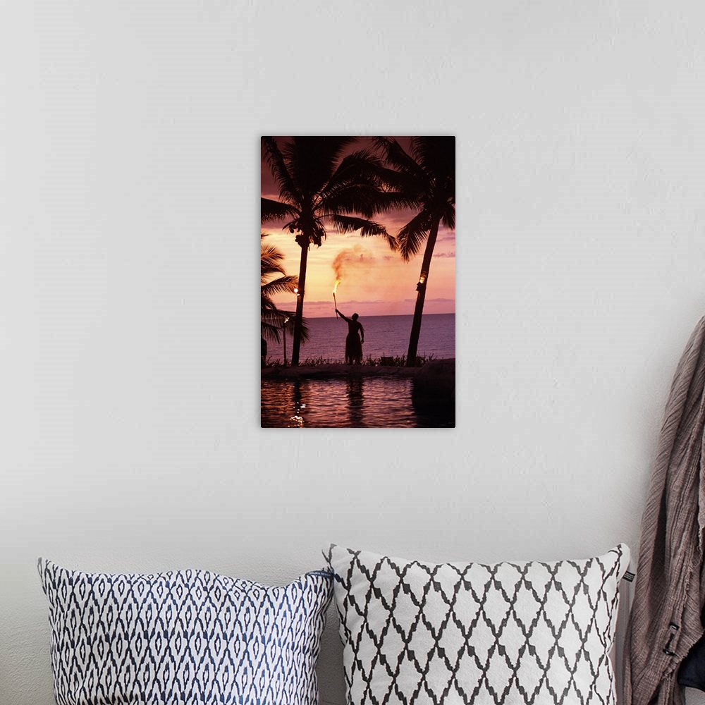 A bohemian room featuring Native In A Grass Skirt Holding A Flaming Torch By Coast At Sunset