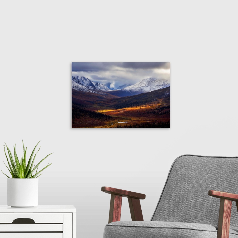 A modern room featuring Storm clouds part allowing light to illuminate the landcape in the North Klondike Valley along th...