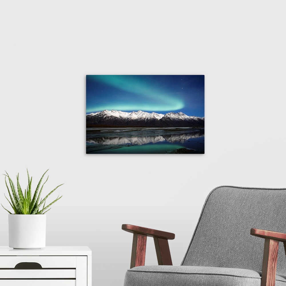 A modern room featuring A landscape photograph of the aurora borealis and mountains reflecting in a lake filled with ice.