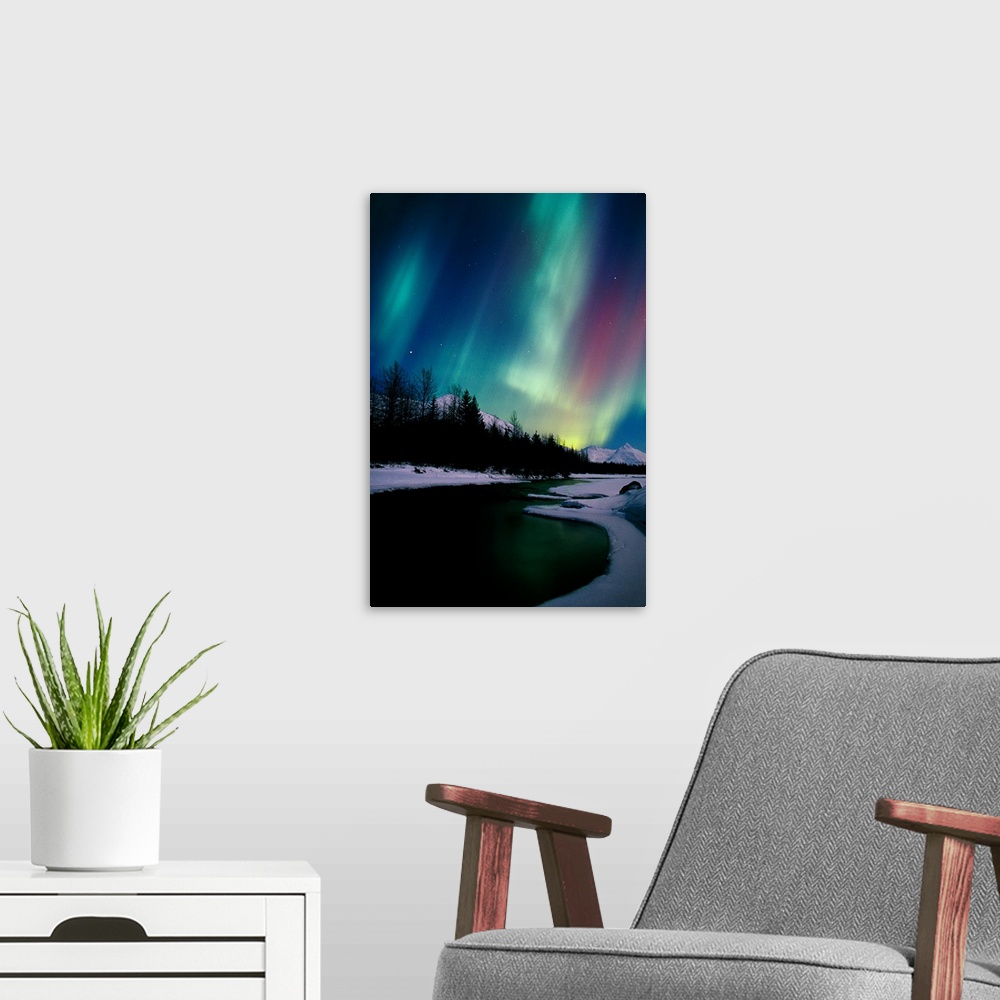 A modern room featuring Giant photograph shows the aurora borealis shining in the nighttime sky over a frozen landscape w...