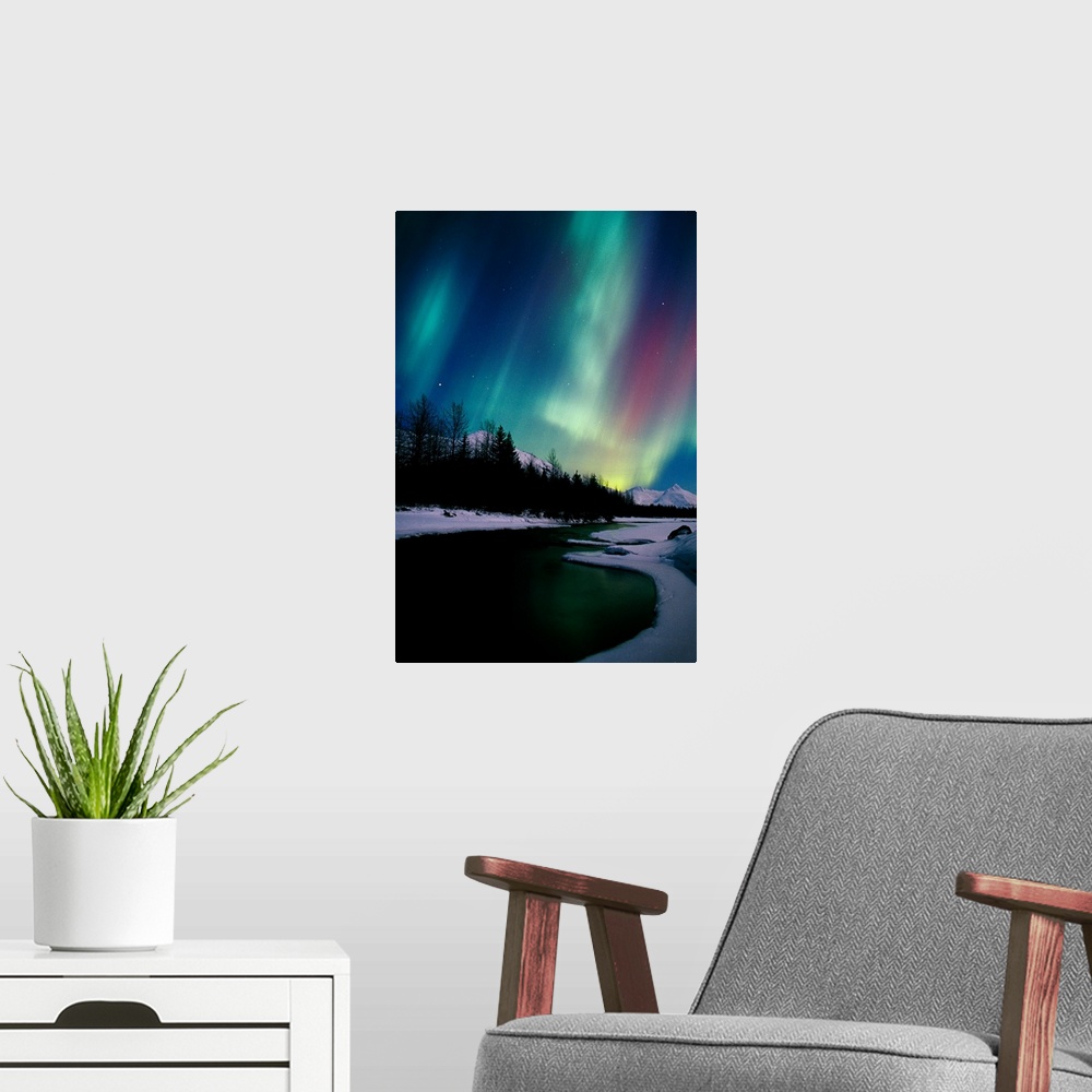 A modern room featuring Giant photograph shows the aurora borealis shining in the nighttime sky over a frozen landscape w...