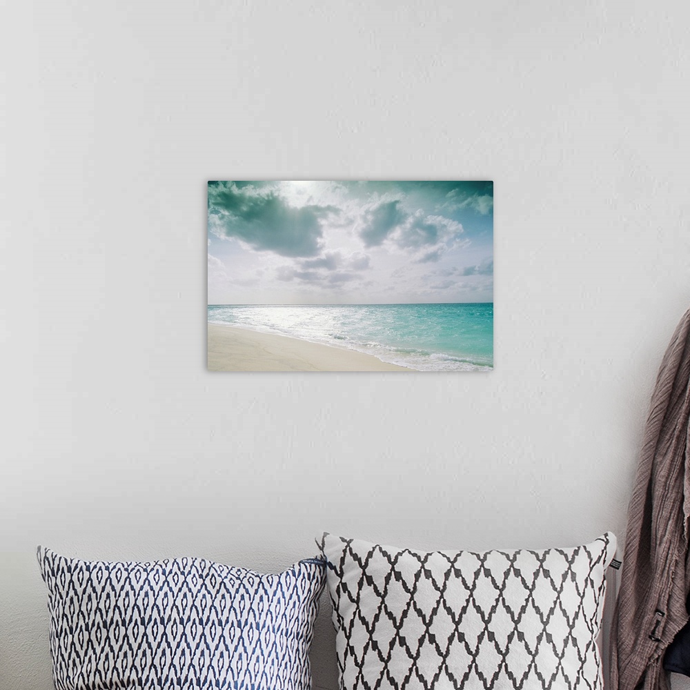 A bohemian room featuring Large, landscape photograph of the shoreline along Sand Island meeting the clear blue waters over...
