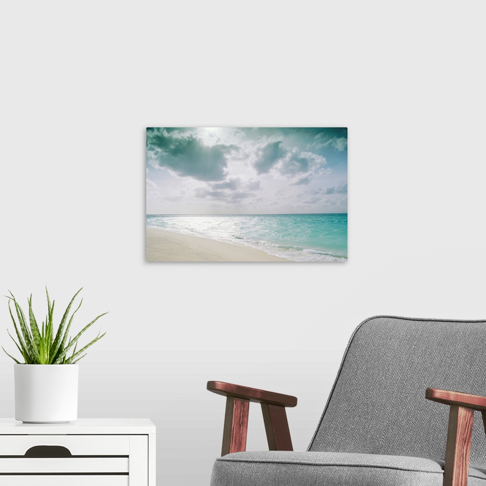 A modern room featuring Large, landscape photograph of the shoreline along Sand Island meeting the clear blue waters over...