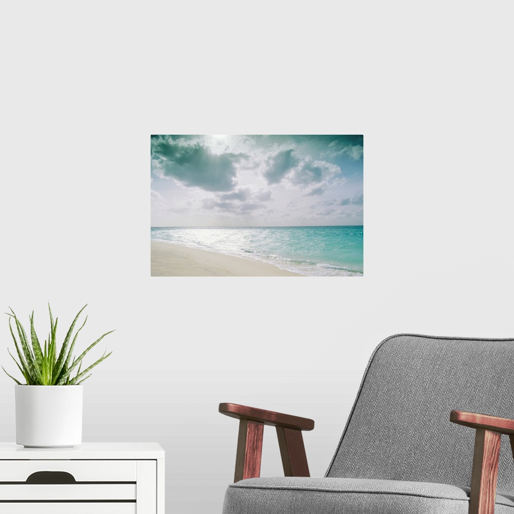 A modern room featuring Large, landscape photograph of the shoreline along Sand Island meeting the clear blue waters over...