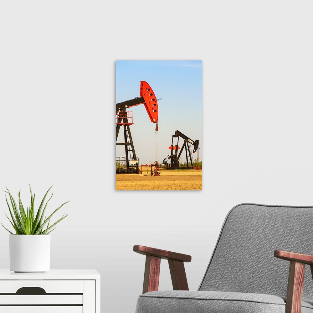 A modern room featuring Oil well pump jacks at Bakken Oil Field near Estevan, Saskatchewan, Canada
