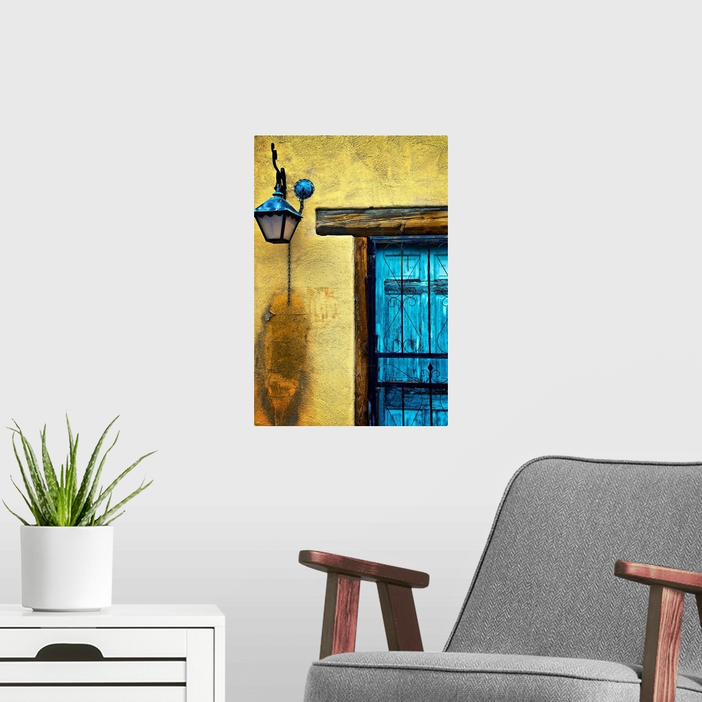 A modern room featuring Vertical panoramic photograph of bright colorful door on stone wall.
