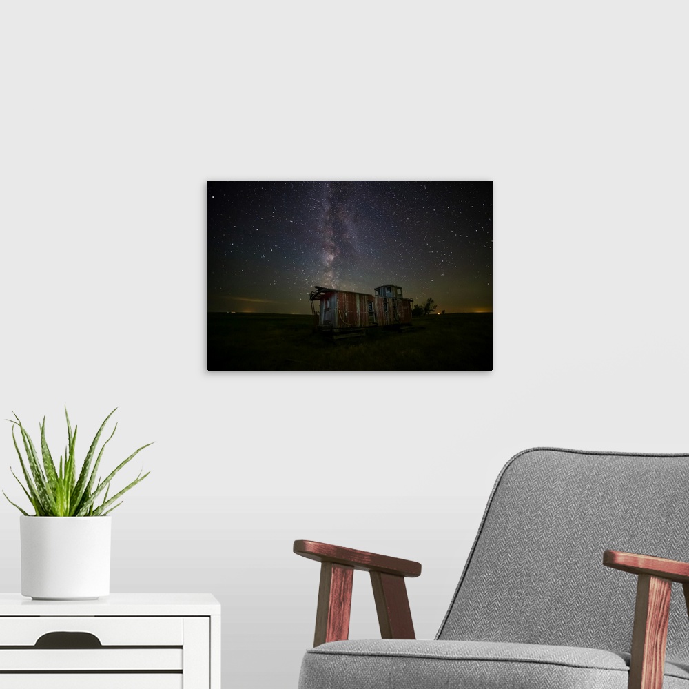 A modern room featuring Old caboose at nighttime under a bright, starry sky; Coderre, Saskatchewan, Canada