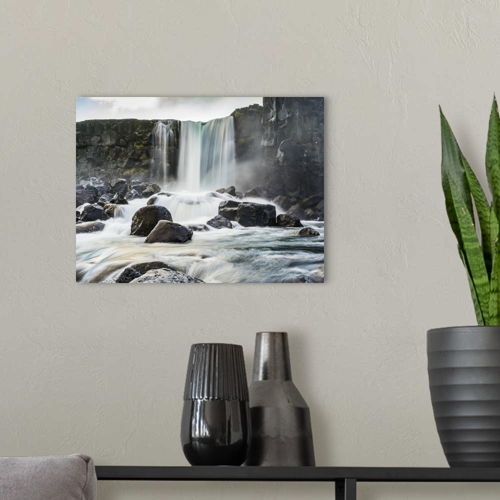 A modern room featuring Oxararfoss waterfall in Thingvellir, a historic site and national park.  It's known for the Althi...