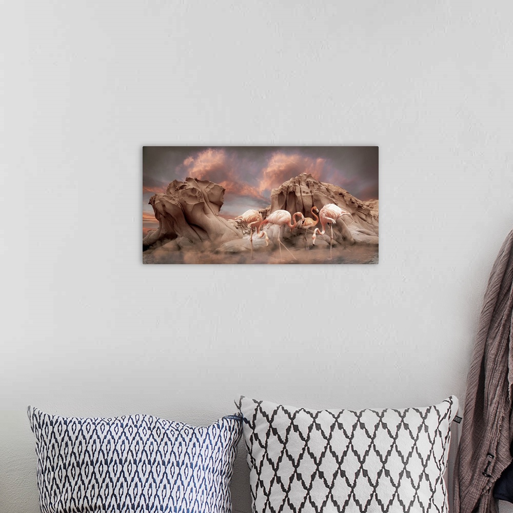A bohemian room featuring Pink flamingoes stand in shallow water in front of rugged rock formations with a dramatic sky of ...