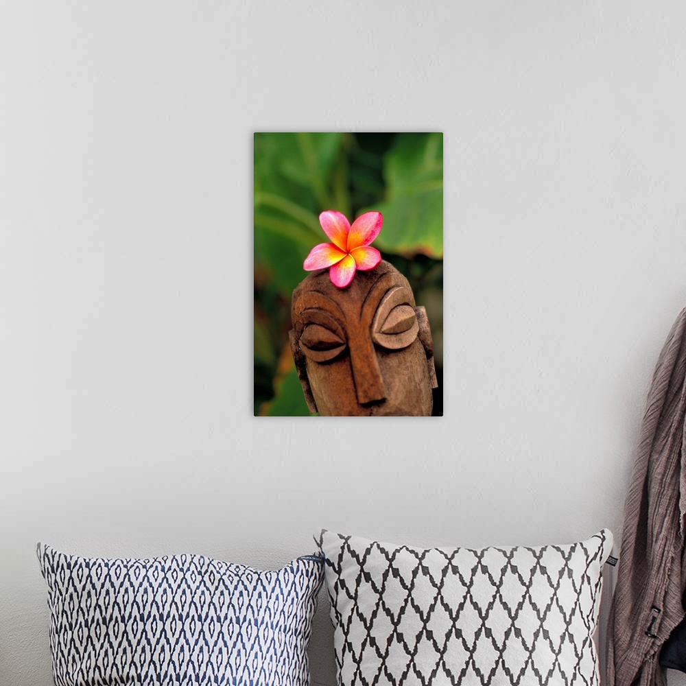 A bohemian room featuring Pink Plumeria Flower Atop Wooden Polynesian Statue Carving, Outdoors