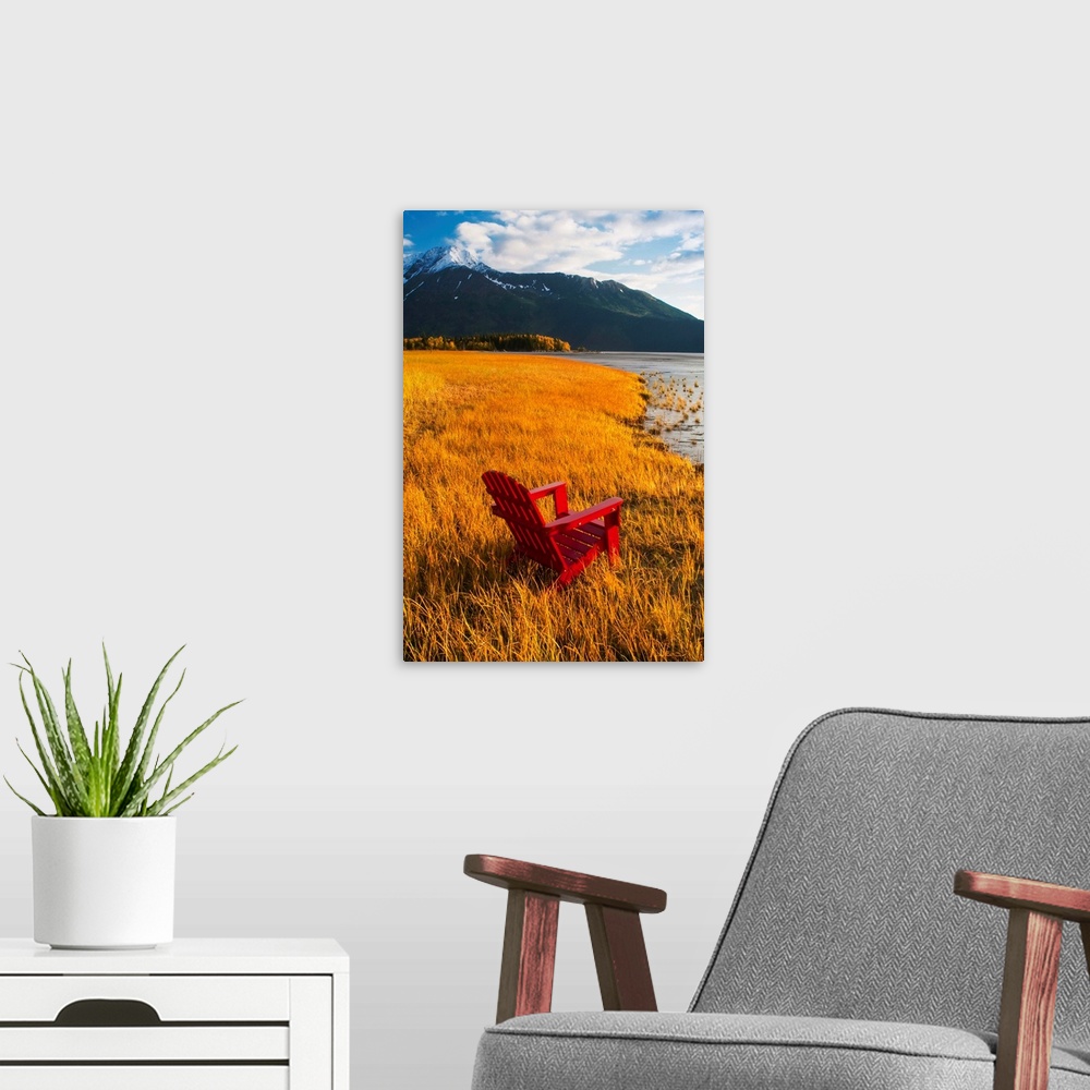 A modern room featuring Vertical, large photograph of a single adirondack chair sitting at the edge of a grassy coastline...