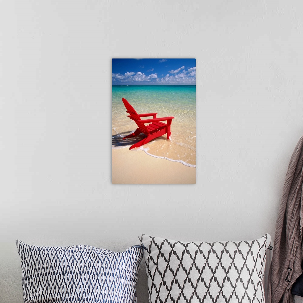 A bohemian room featuring This vertical photograph is taken of a single red beach chair sitting on the edge of the water wi...