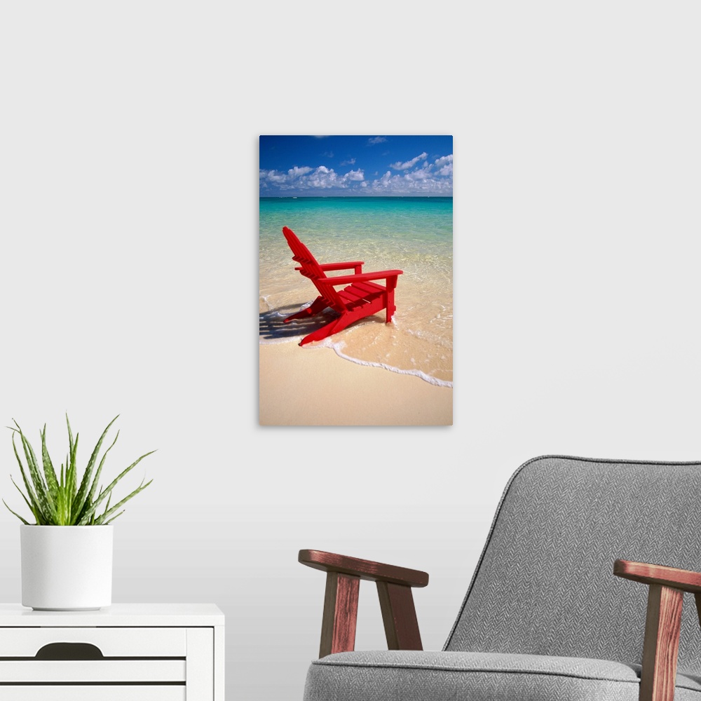 A modern room featuring This vertical photograph is taken of a single red beach chair sitting on the edge of the water wi...
