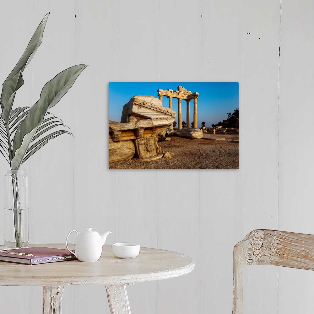 A farmhouse room featuring Roman and Hellenistic ruins of the Temple of Apollo under a bright blue sky at sunrise, a ruined ...