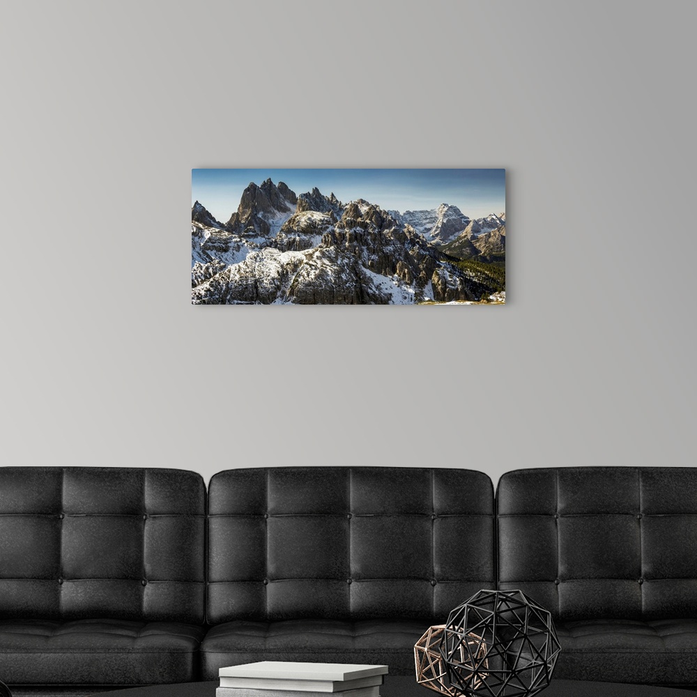 A modern room featuring Rugged snow-covered mountain range with blue sky, San Candido, Bolzano, Italy.