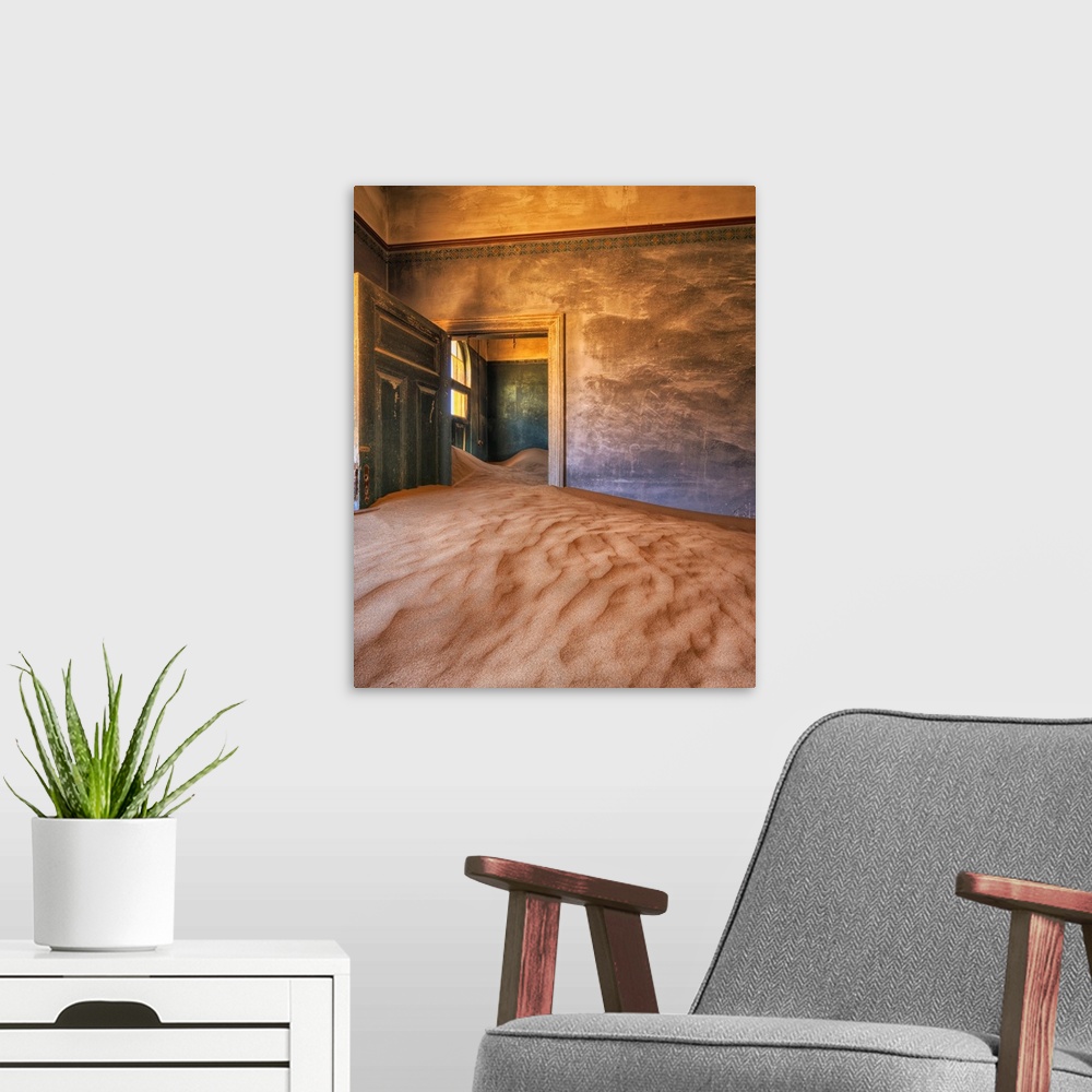 A modern room featuring Sand in the rooms of a colourful and abandoned house. Kolmanskop, Namibia.