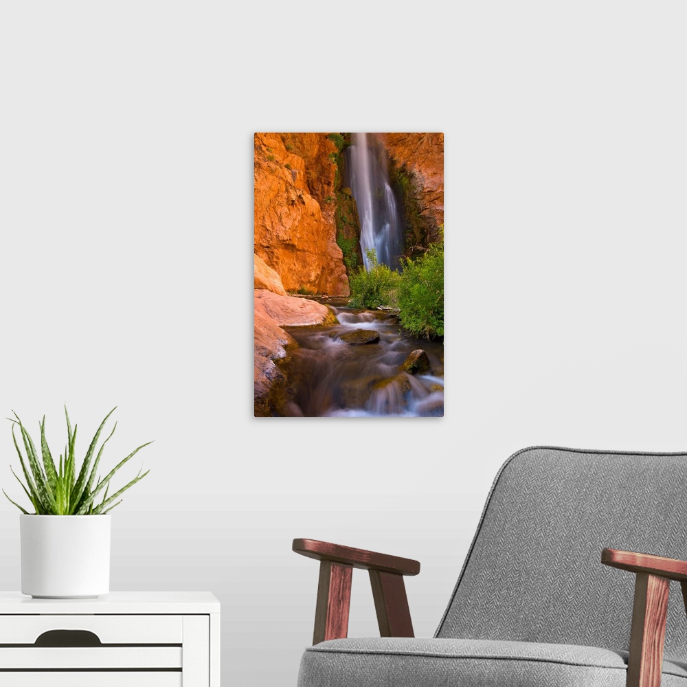 A modern room featuring This photograph is from the National Geographic Collection showing a waterfall cascading into a s...