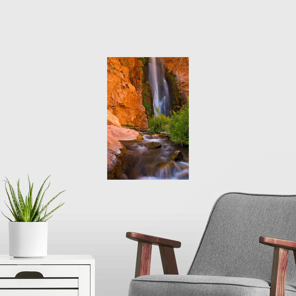 A modern room featuring This photograph is from the National Geographic Collection showing a waterfall cascading into a s...