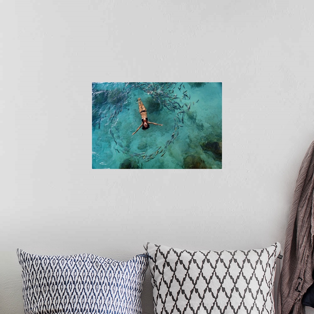 A bohemian room featuring School Of Fish Encircling Woman Floating In Tropical Ocean Water