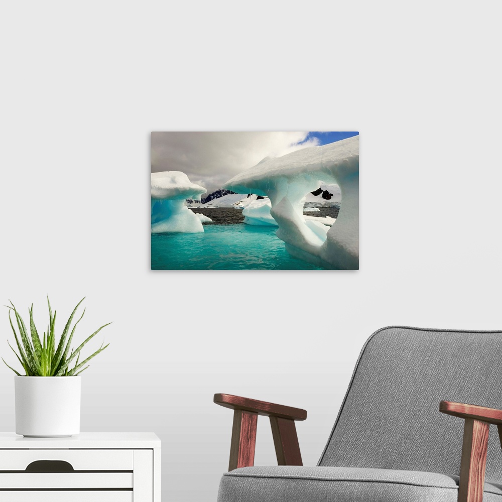 A modern room featuring Sculpted icebergs under clouds near the shore of Couverviller Island.