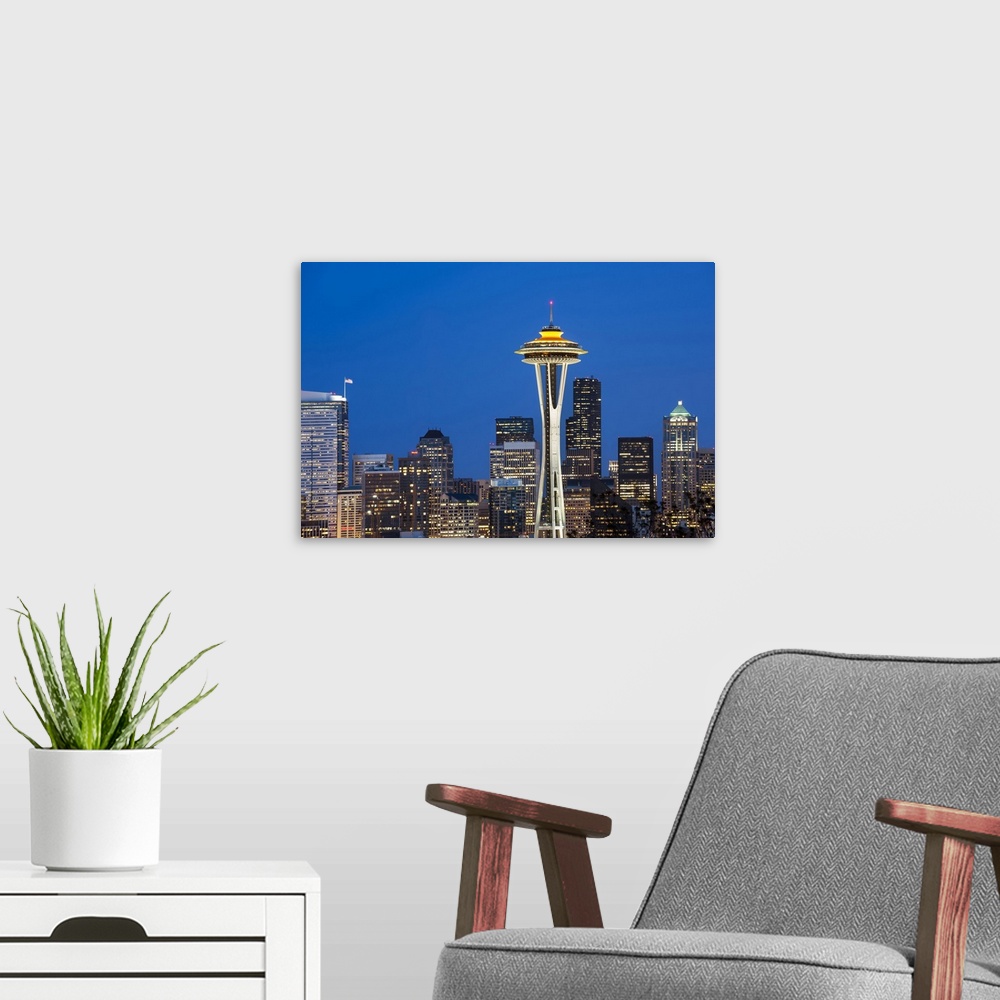A modern room featuring Seattle and the Space Needle by night.