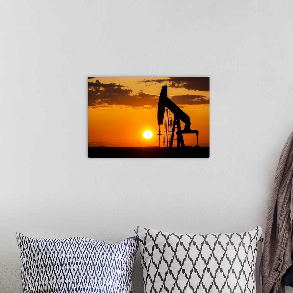 A bohemian room featuring Silhouette Of A Pump Jack At Sunrise With A Colorful Orange Sun, Clouds And Sky; Alberta, Canada