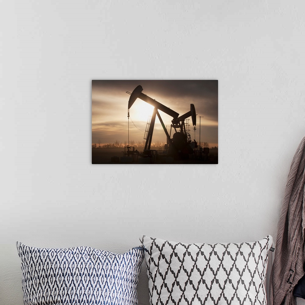A bohemian room featuring Silhouette Of Two Pump Jacks At Sunrise With Clouds; Alberta, Canada