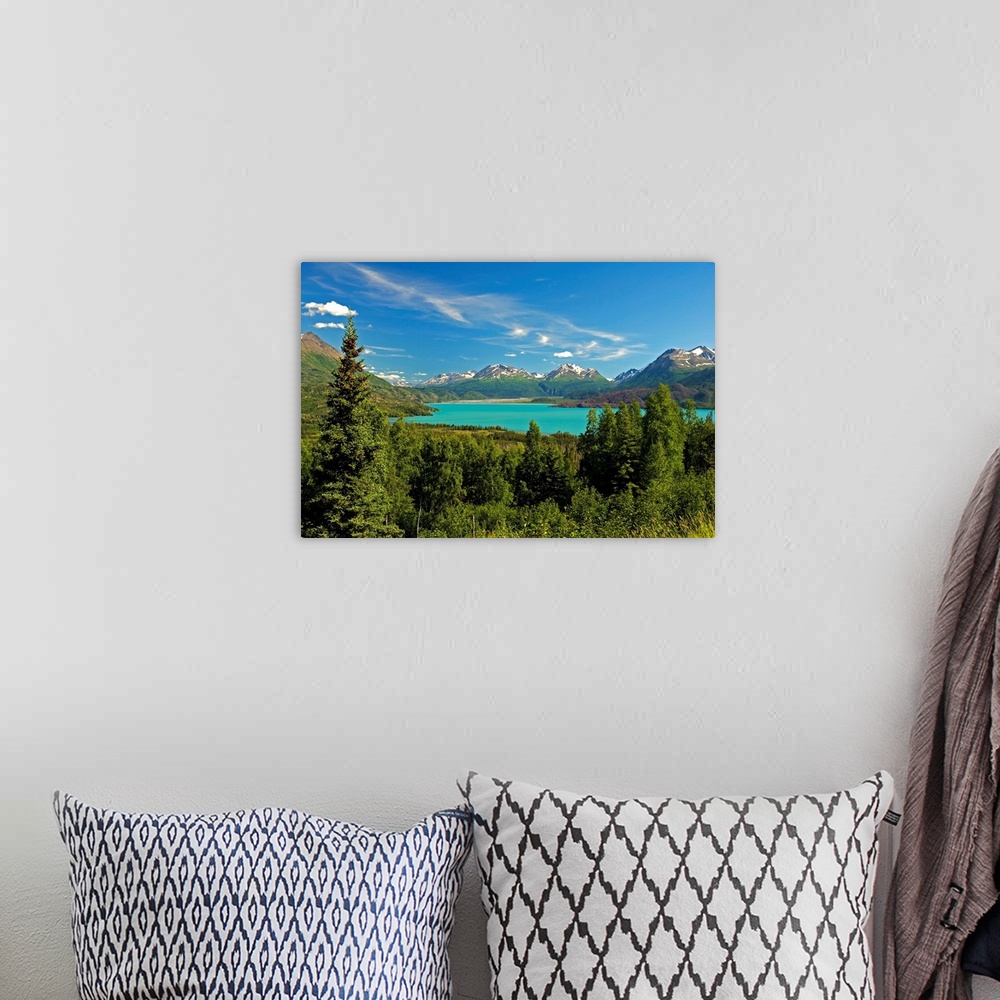 A bohemian room featuring Large canvas photo art of a forest surrounding a clear lake with snowcapped mountains in the dist...
