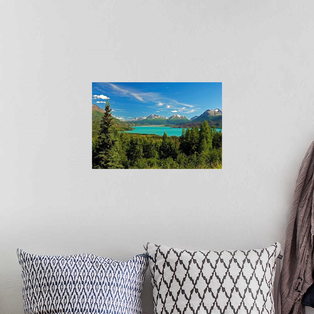 A bohemian room featuring Large canvas photo art of a forest surrounding a clear lake with snowcapped mountains in the dist...