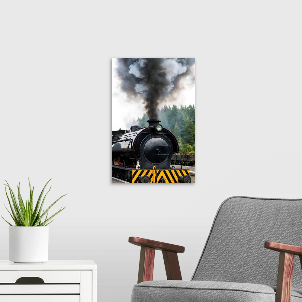 A modern room featuring Smoke billows from the engine of a train; North Yorkshire, England
