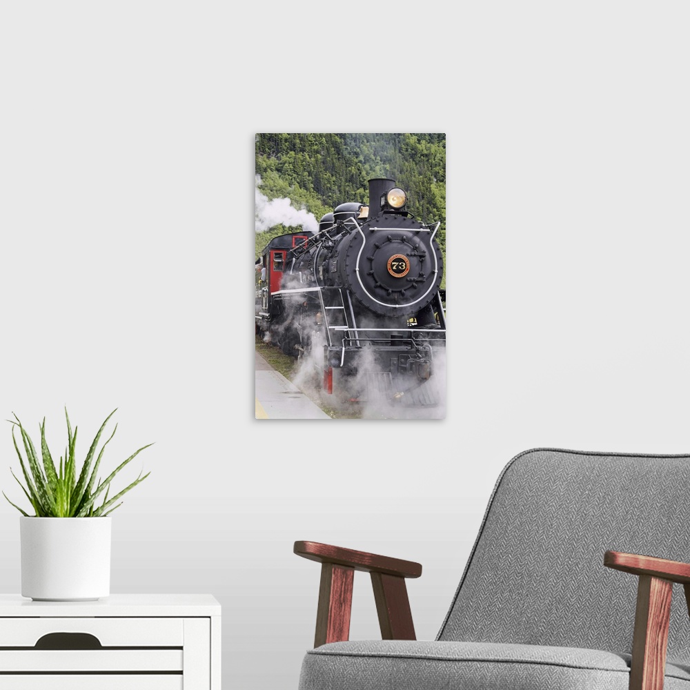 A modern room featuring Steam locomotive 73 at downtown depot of White Pass and Yukon Route RR in Skagway, Alaska. Narrow...