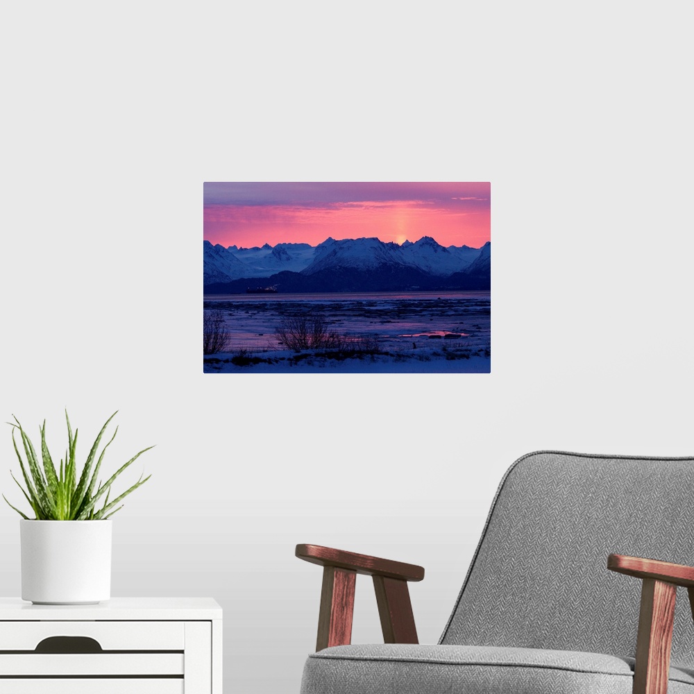 A modern room featuring Photo print of rocky mountains with the sun setting behind them.