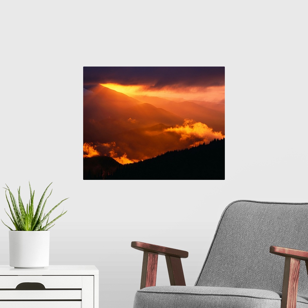 A modern room featuring Sun setting behind mountain range, Olympic national park, Washington state, USA. Washington, unit...
