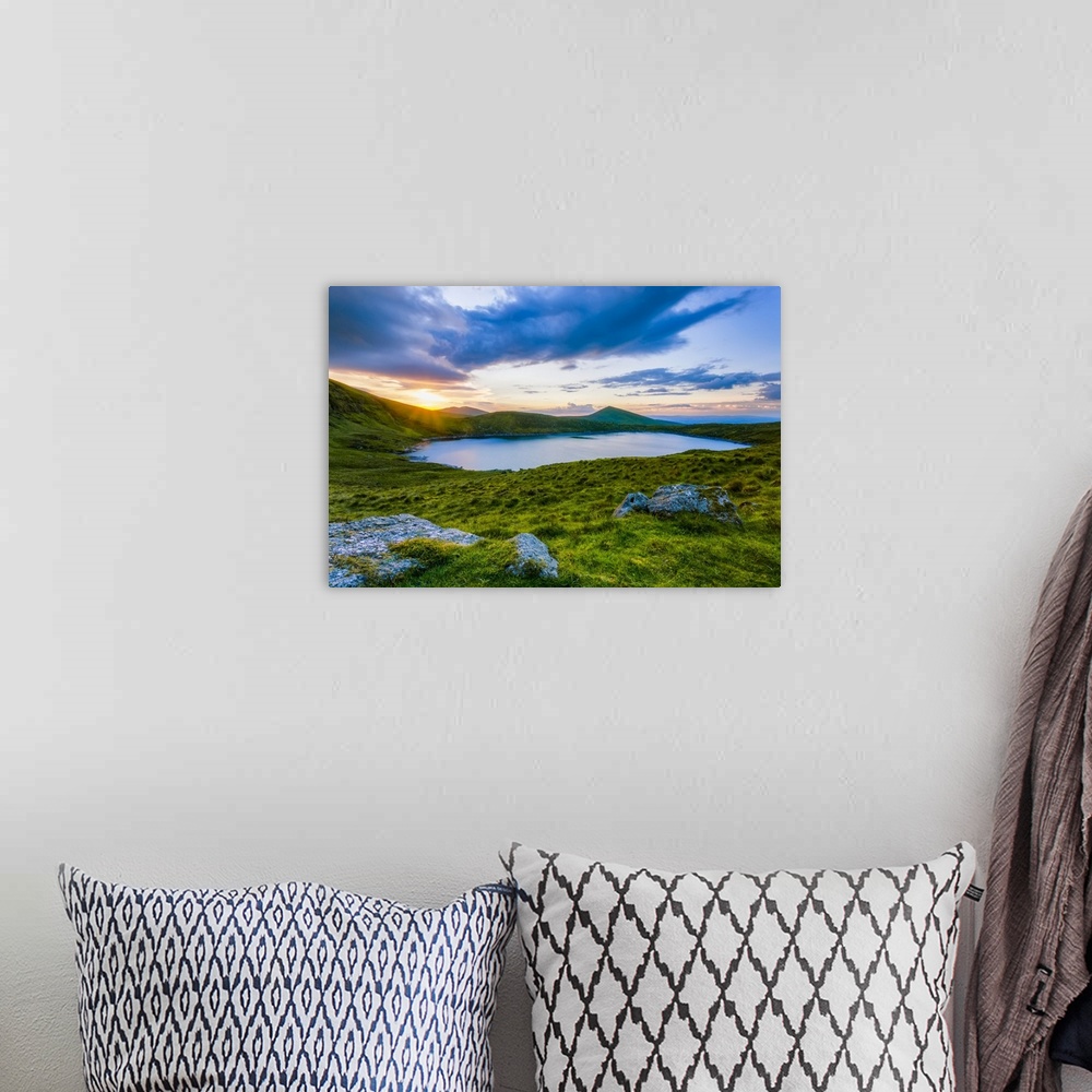 A bohemian room featuring Sun setting over Lough Muskery in the Galty Mountains in summer with large boulders in the foregr...